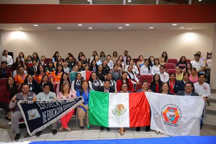 Fotografía grupal de participantes reunidos en un auditorio durante la apertura del intercambio